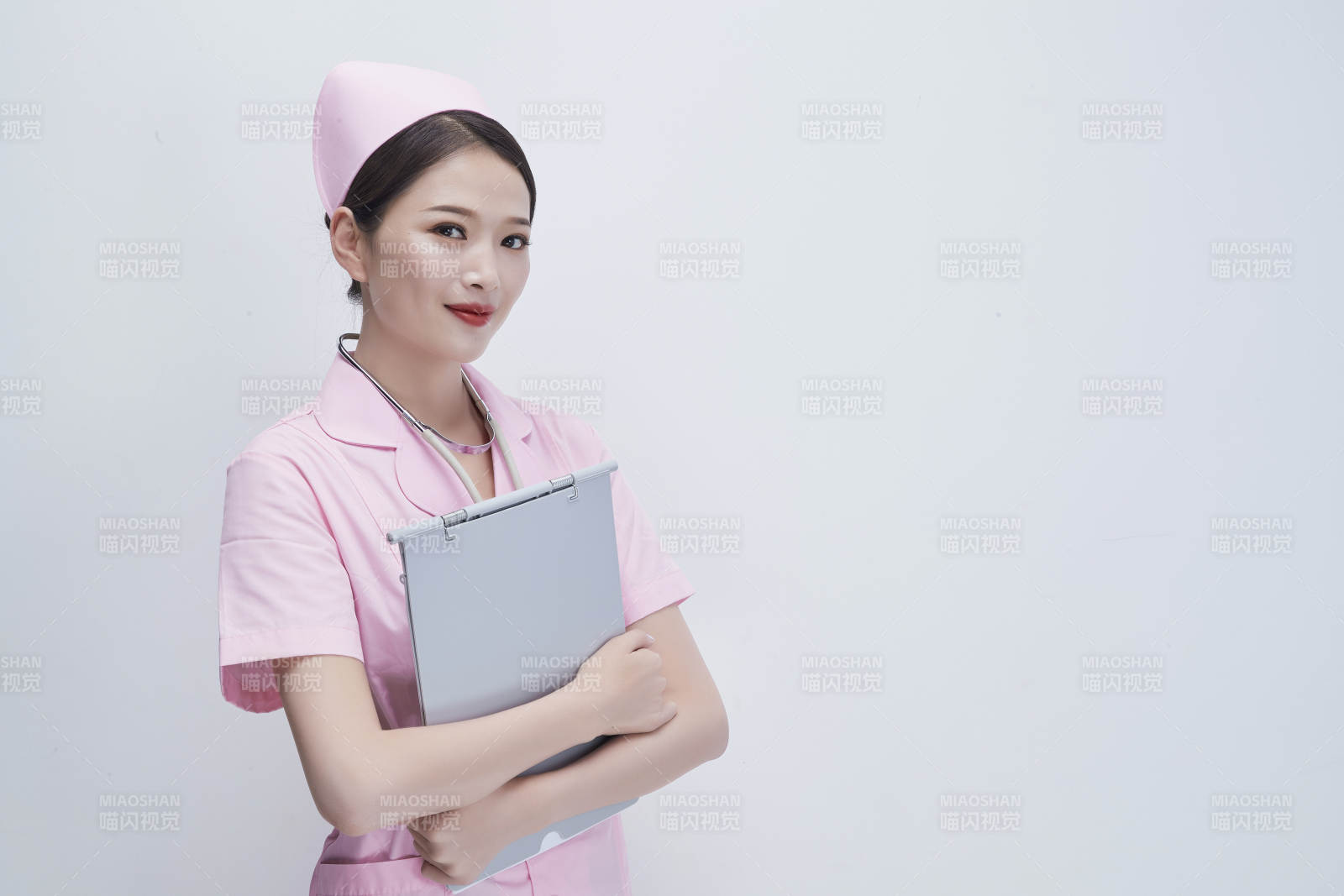 穿粉色護士服戴聽診器手持病歷夾的醫護人員