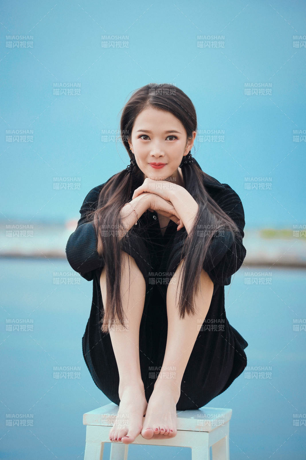 悠閑的坐在美麗湖岸碼頭的亞洲年輕女性人像