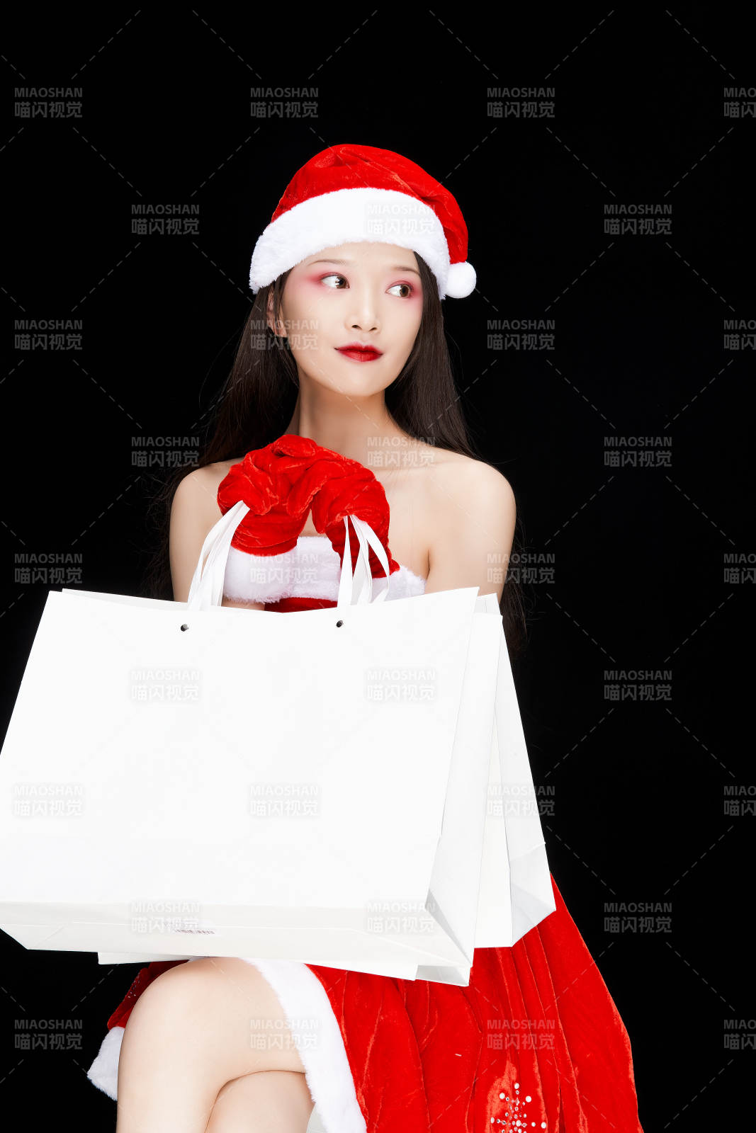 身穿圣誕服飾手提購物袋性感可愛的圣誕女郎