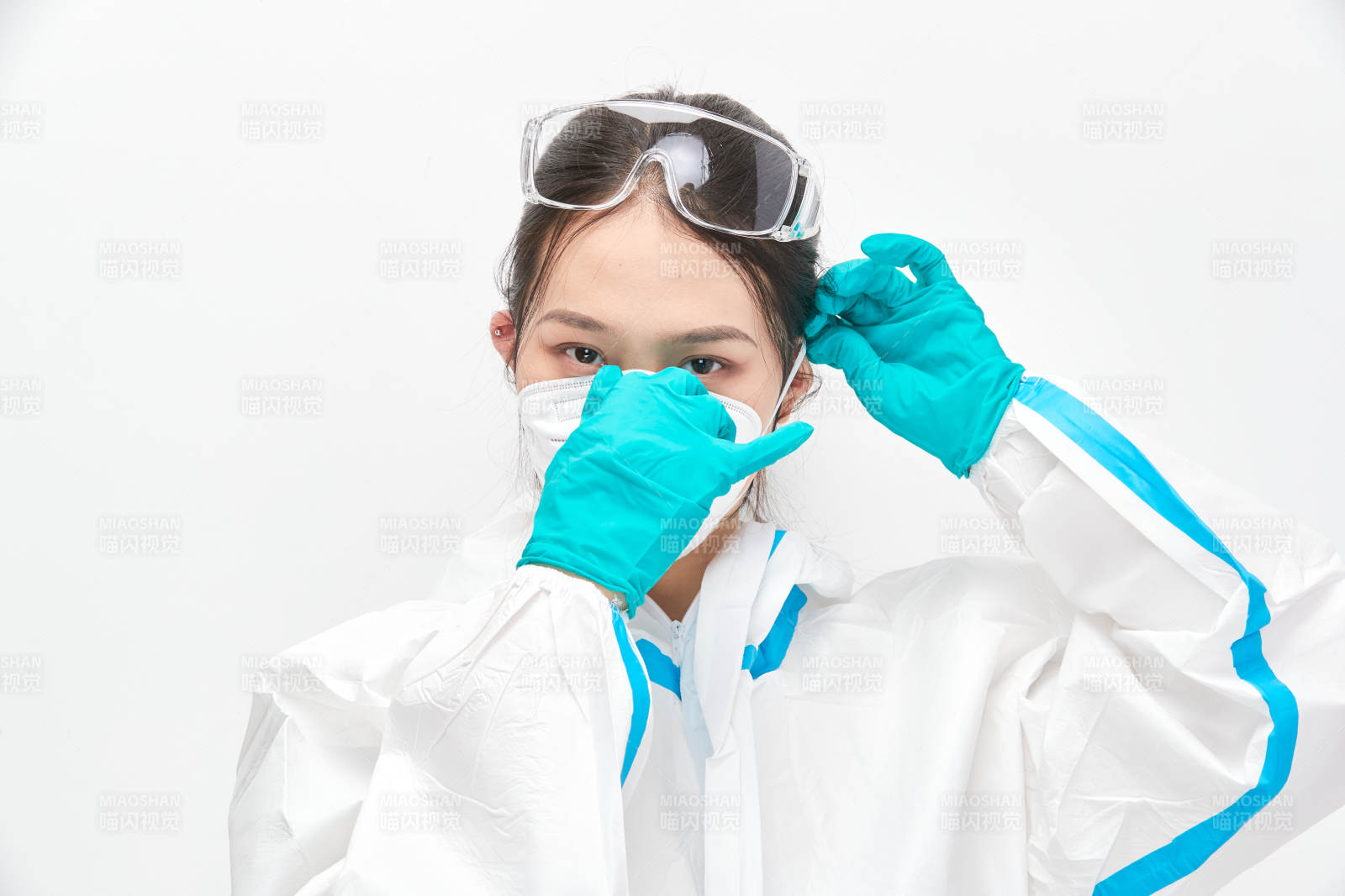 穿白色防護(hù)服佩戴護(hù)目鏡口罩的女性醫(yī)療人員