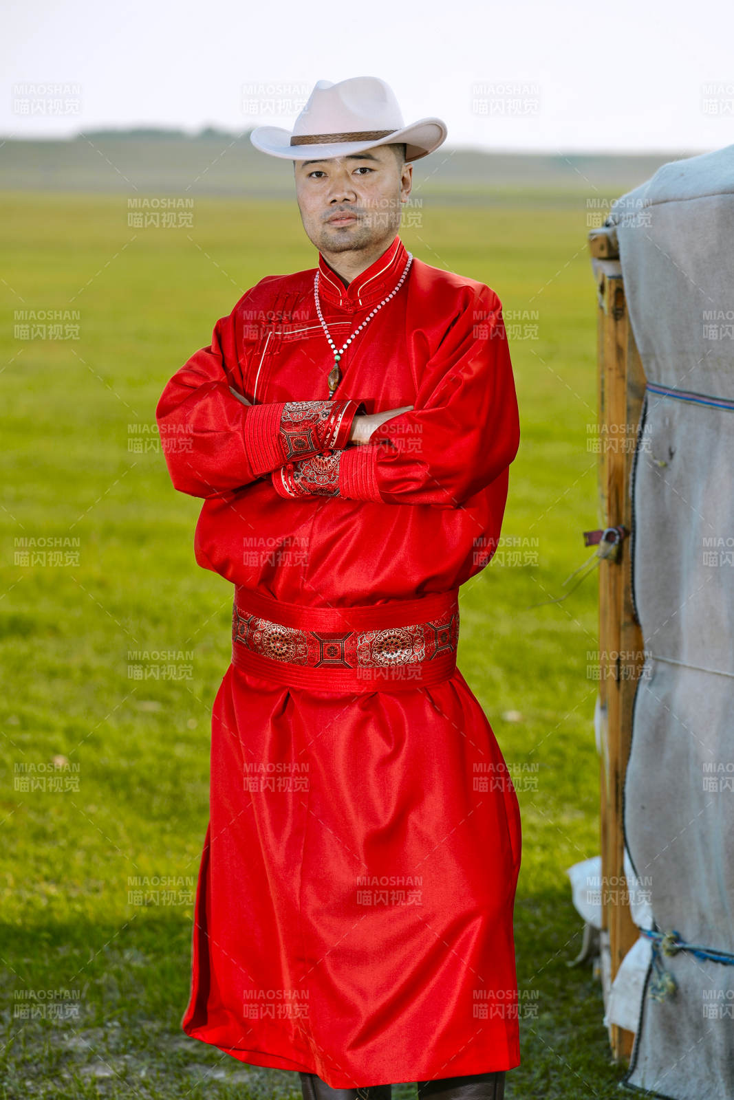 草原上蒙古包前身穿蒙古族傳統服飾的男子