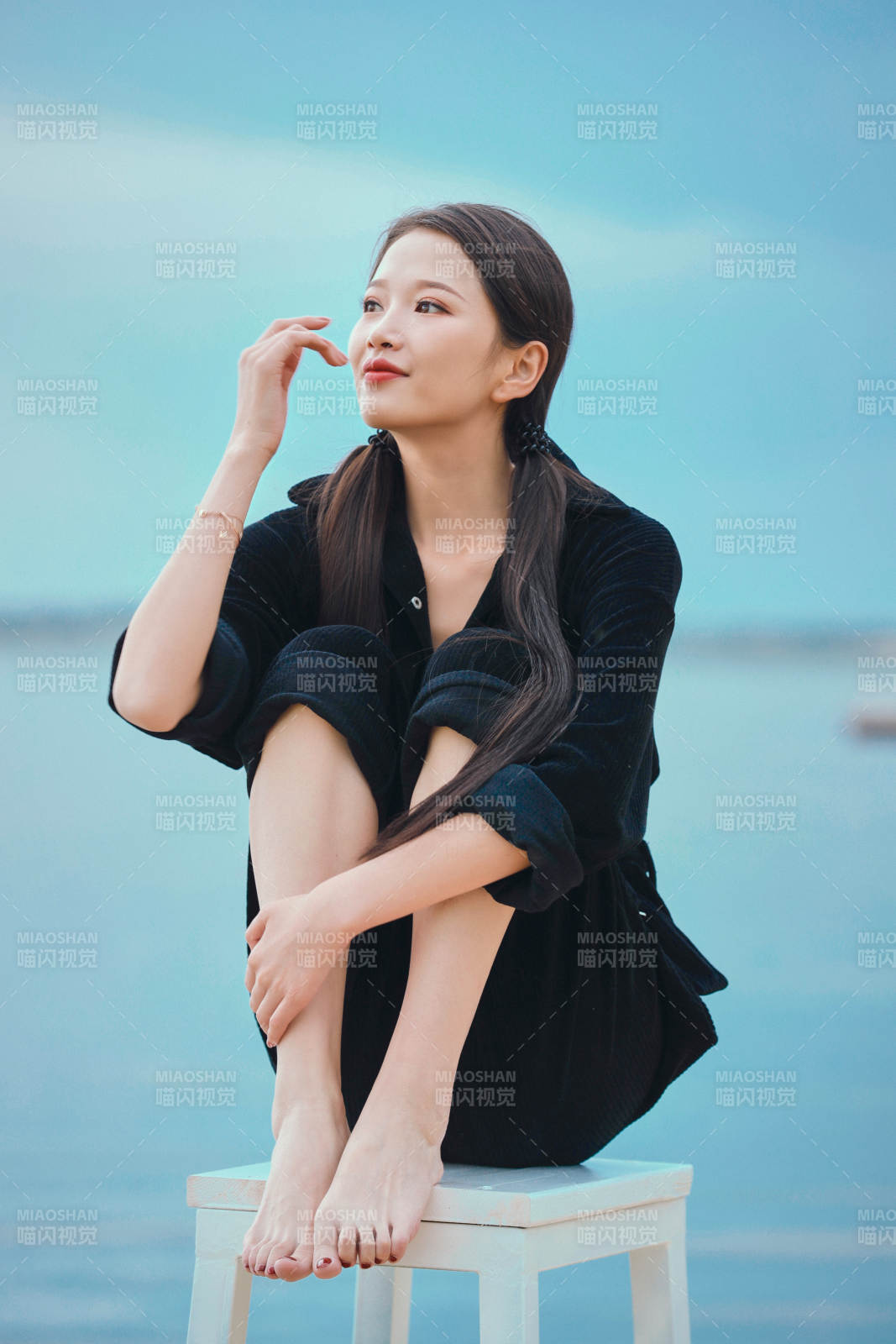 悠閑的坐在美麗湖岸碼頭的亞洲年輕女性人像