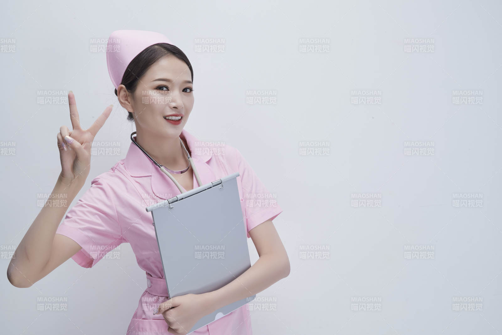 穿粉色護士服戴聽診器手持病歷夾的醫護人員