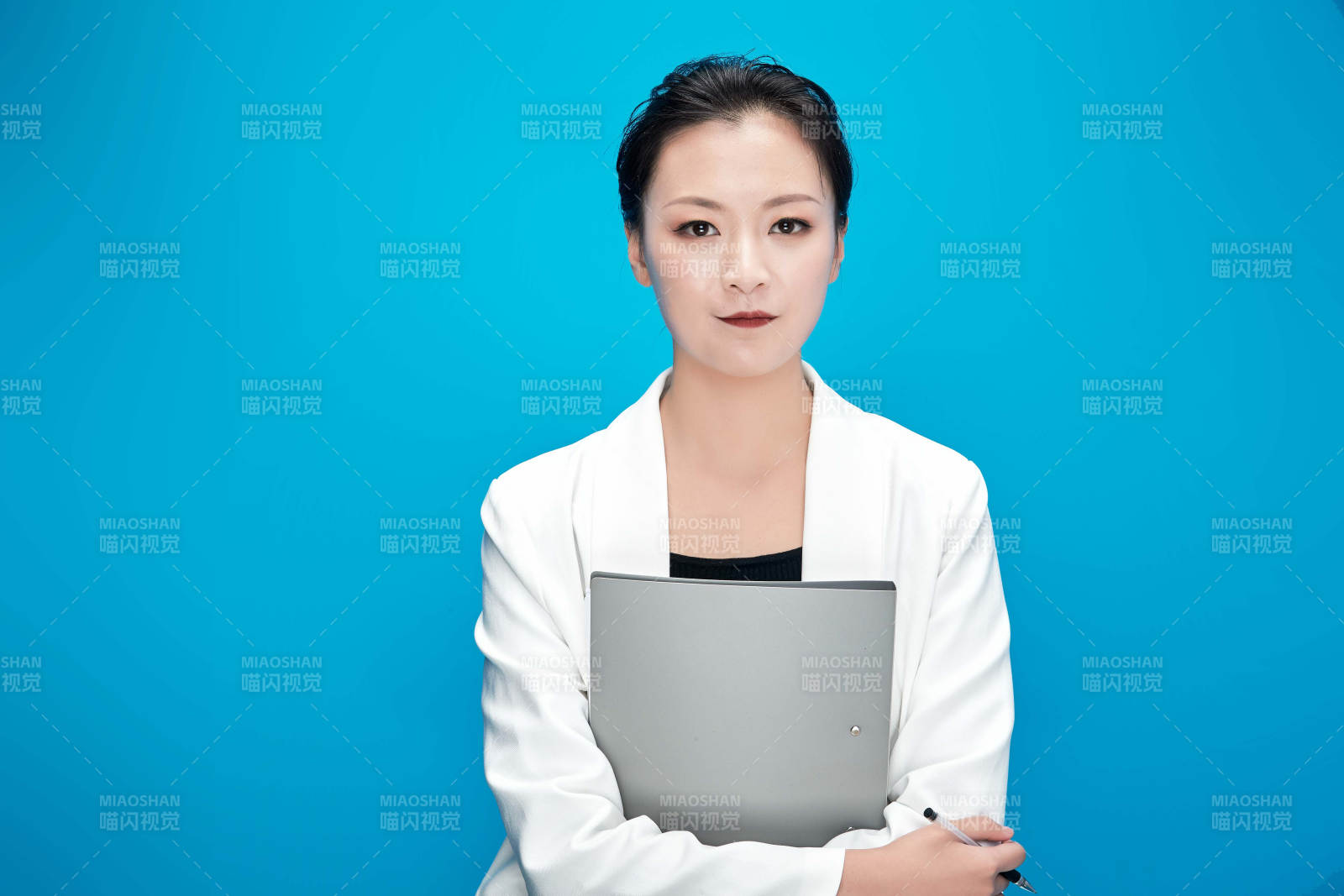 身穿西服拿著手機與文件夾的亞洲商務女士