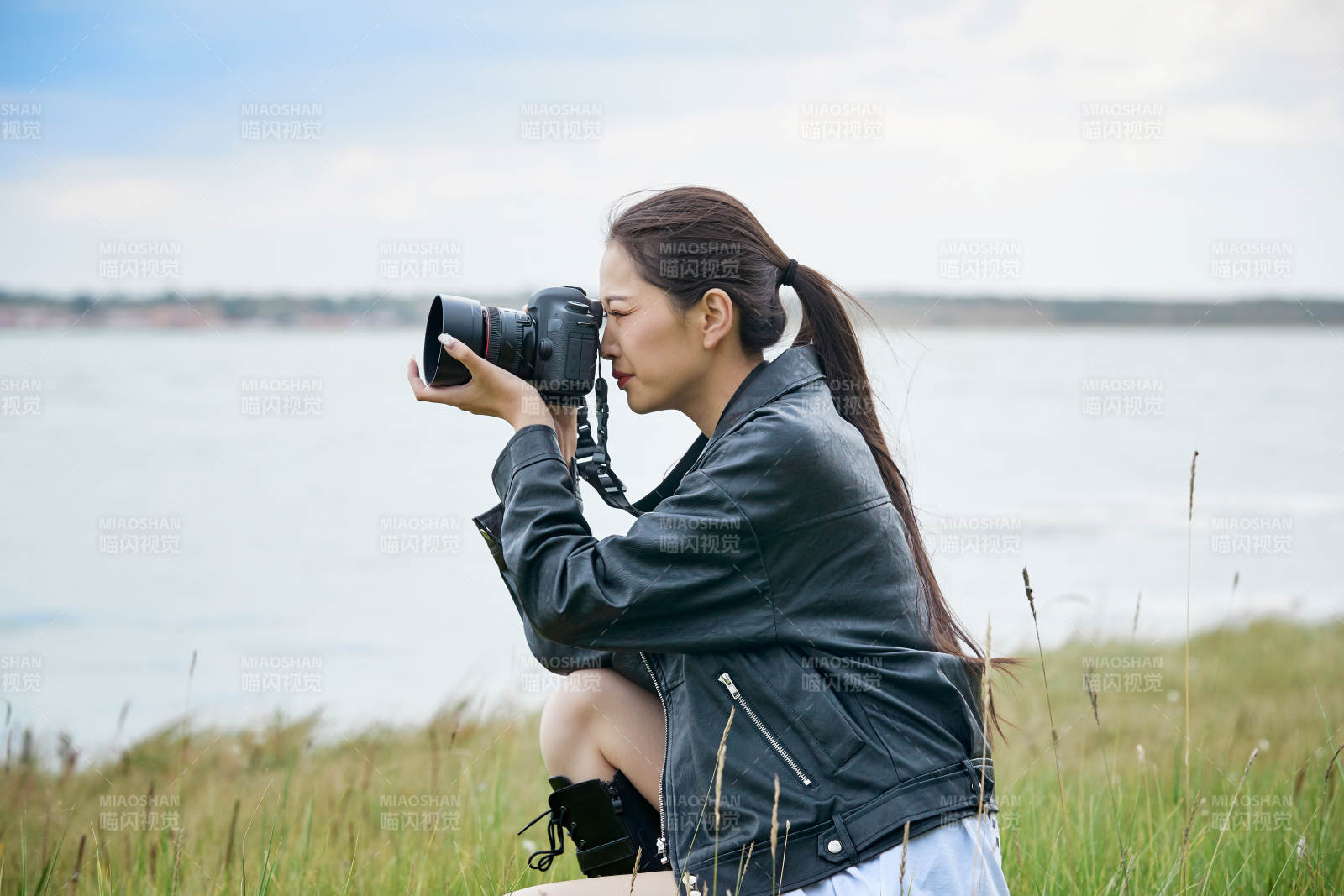 戶外湖畔進行拍攝的亞洲青年女性攝影師