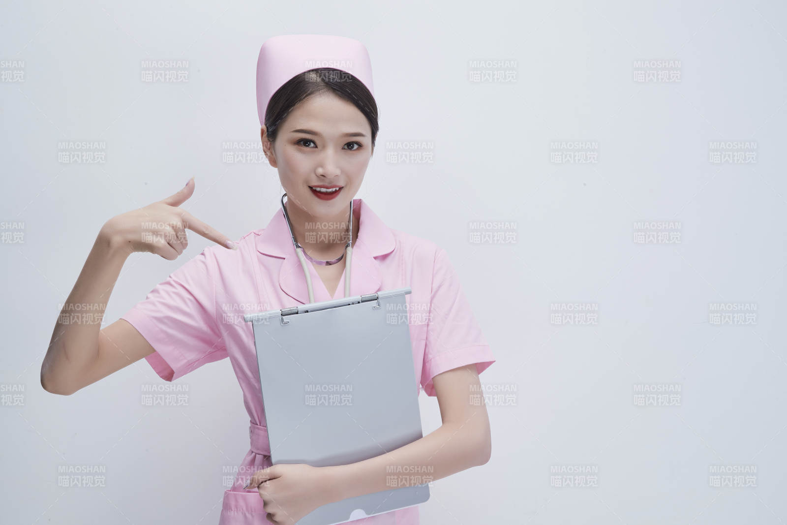 穿粉色護士服戴聽診器手持病歷夾的醫護人員