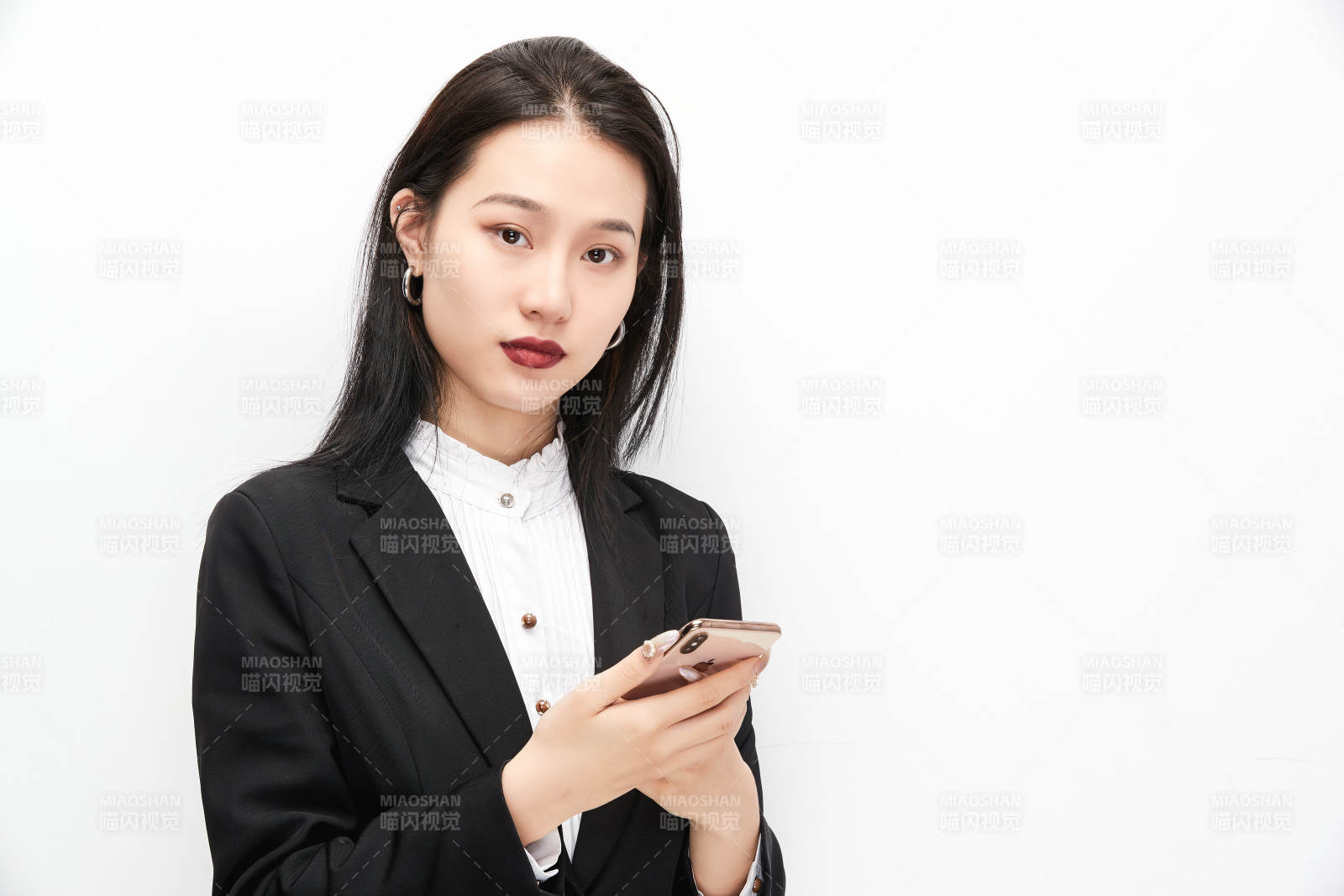 身穿西服拿著手機的美麗商務女士