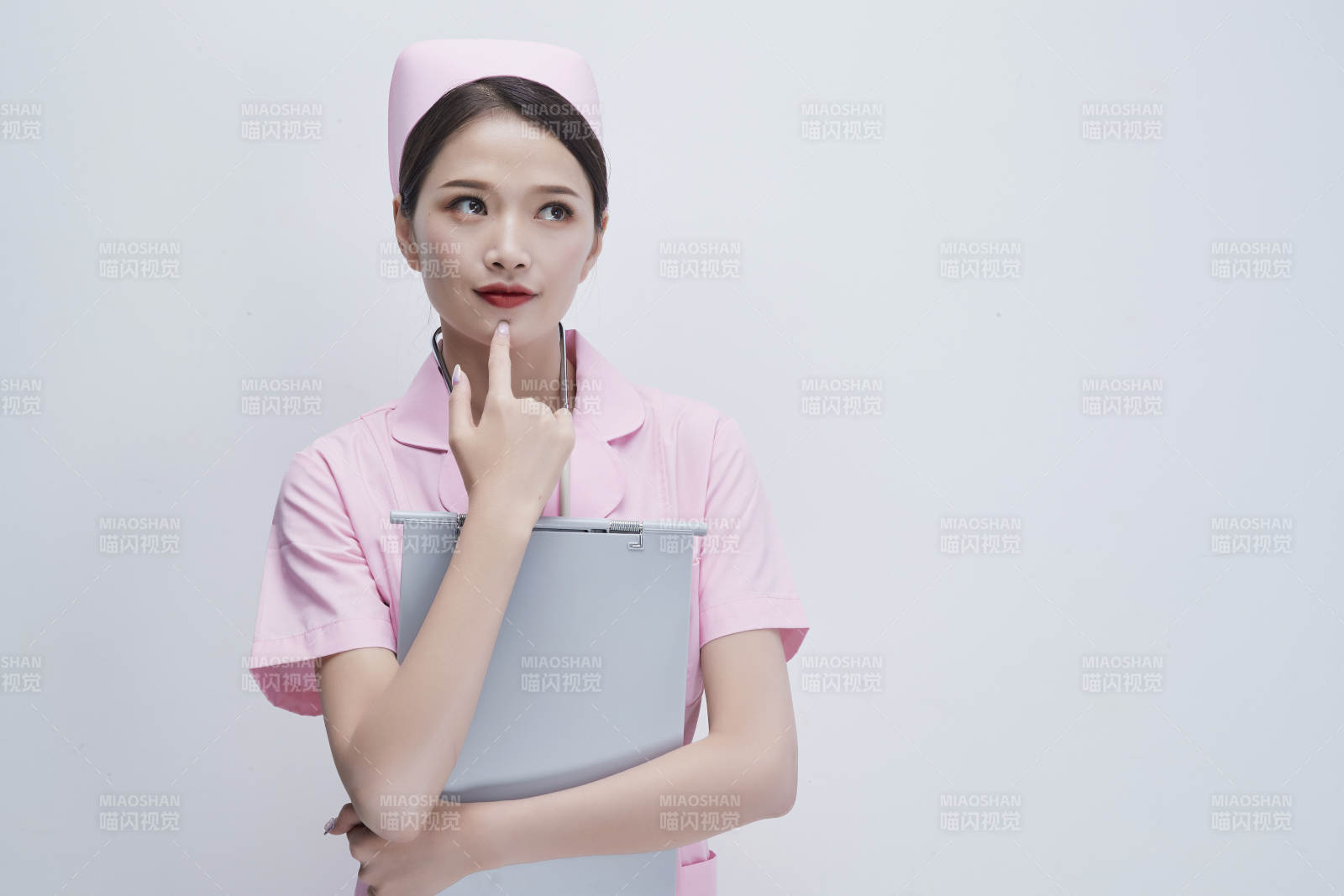 穿粉色護士服戴聽診器手持病歷夾的醫護人員