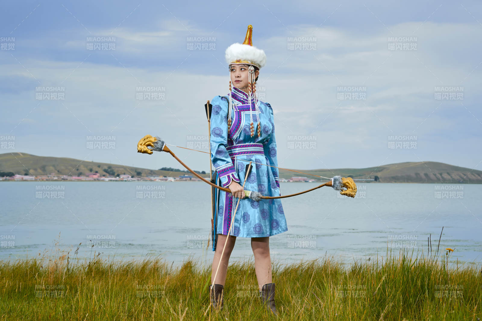 草原湖畔身穿蒙古族飾手持弓箭的蒙族少女
