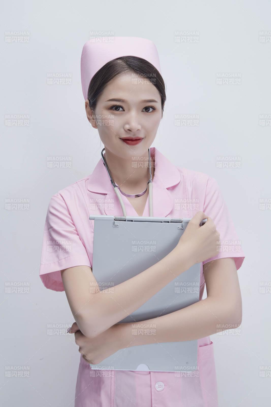 穿粉色護士服戴聽診器手持病歷夾的醫護人員