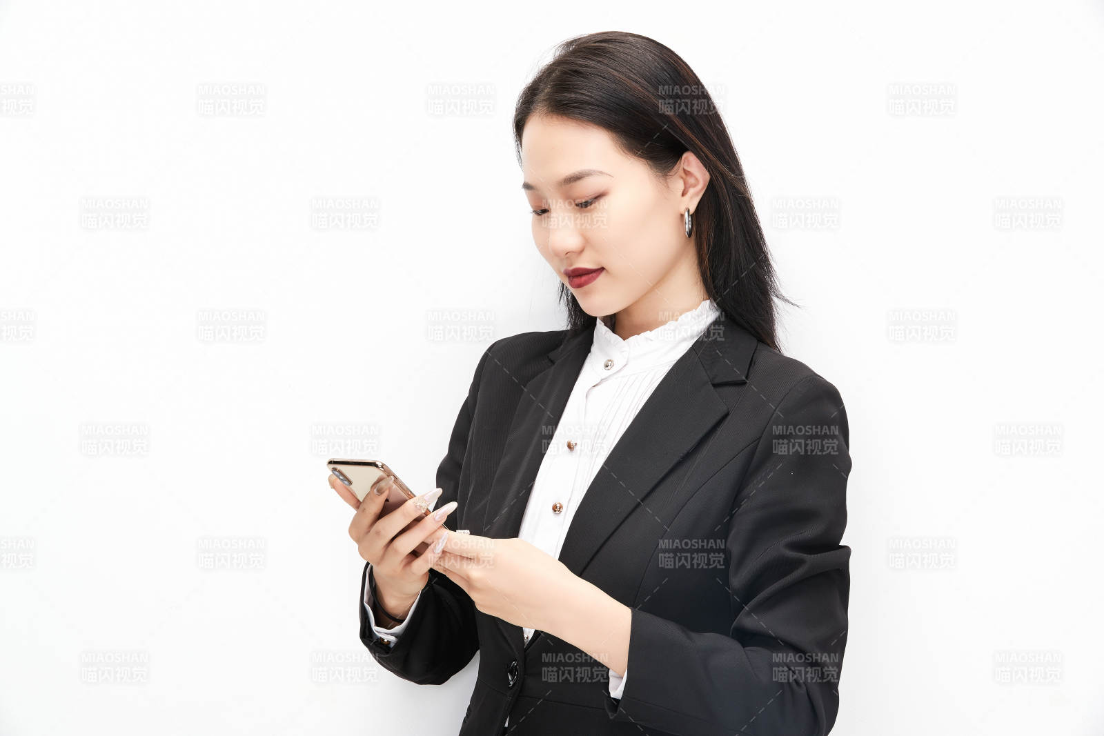 身穿西服拿著手機(jī)的美麗商務(wù)女士