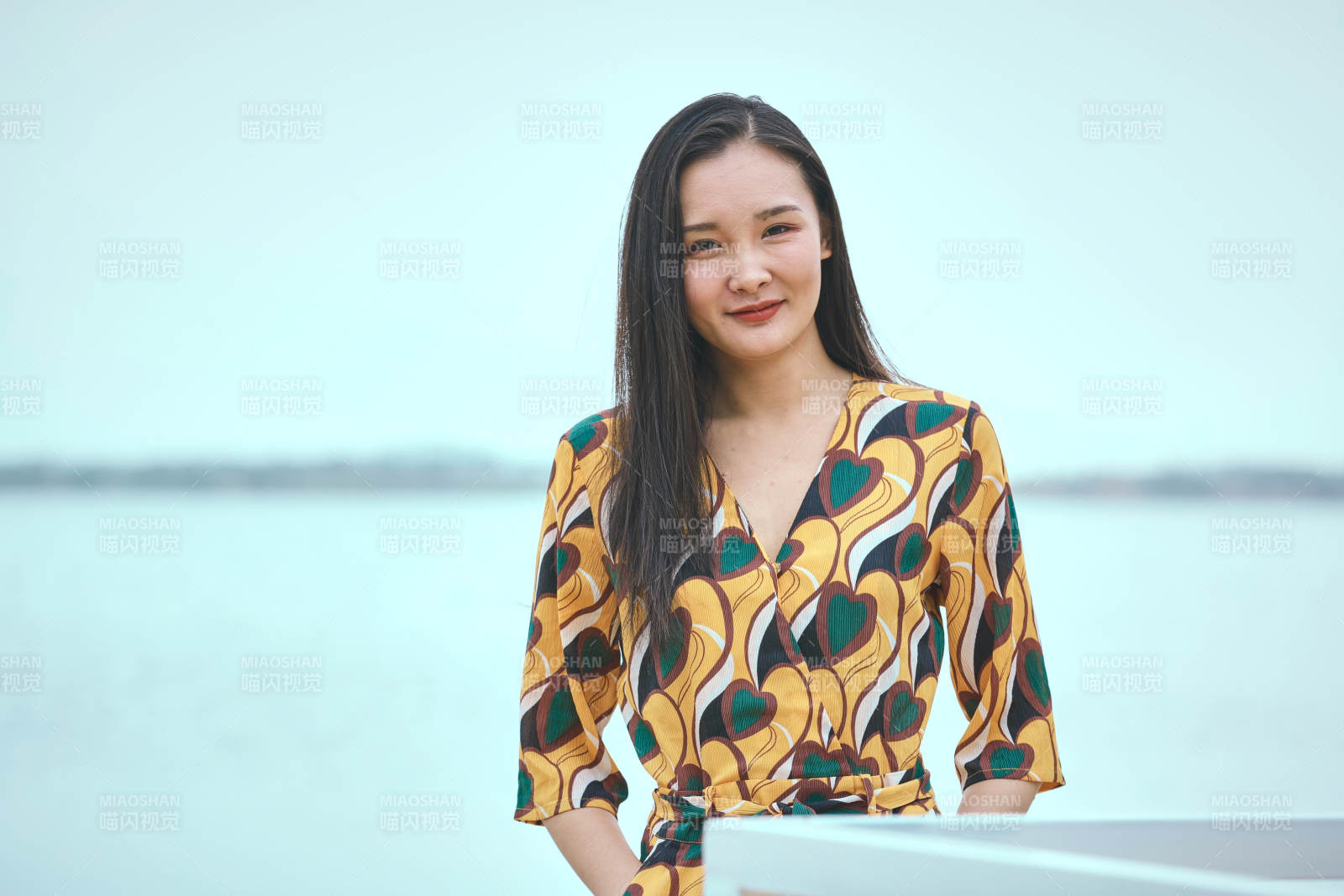 悠闲的坐在美丽湖岸码头的亚洲年轻女性人像