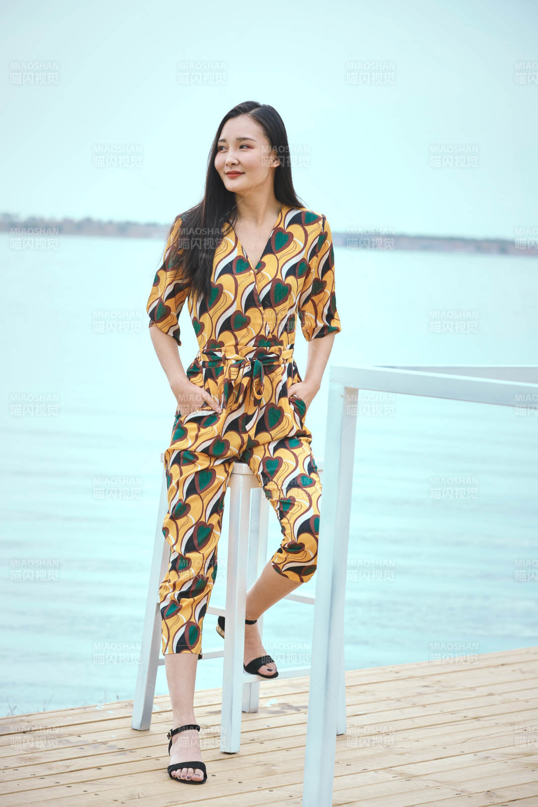 悠閑的坐在美麗湖岸碼頭的亞洲年輕女性人像