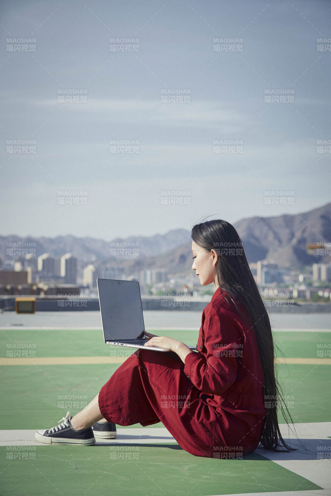 亞洲商務(wù)年輕女性在樓頂停機(jī)坪使用電腦辦公