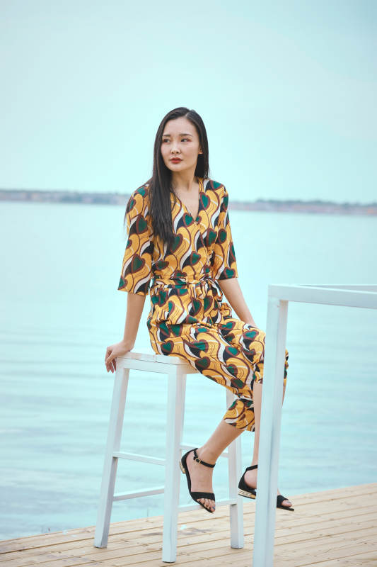 悠闲的坐在美丽湖岸码头的亚洲年轻女性人像