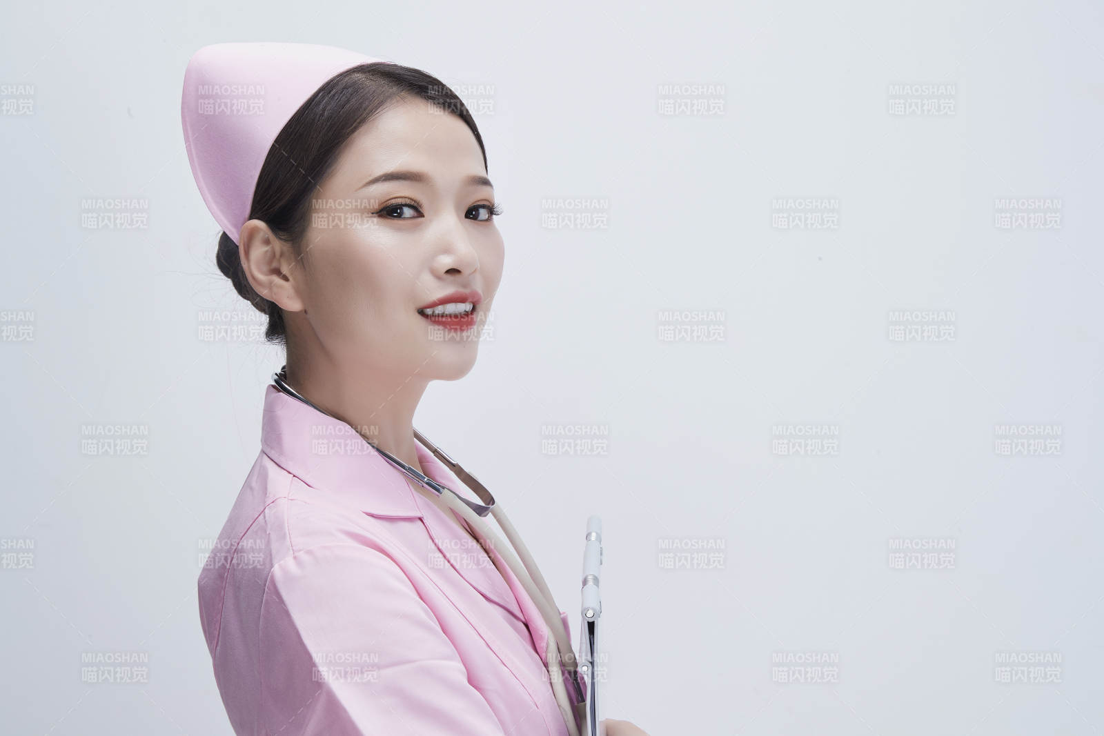 穿粉色護士服戴聽診器手持病歷夾的醫護人員