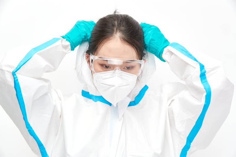 穿白色防护服佩戴护目镜口罩的女性医疗人员