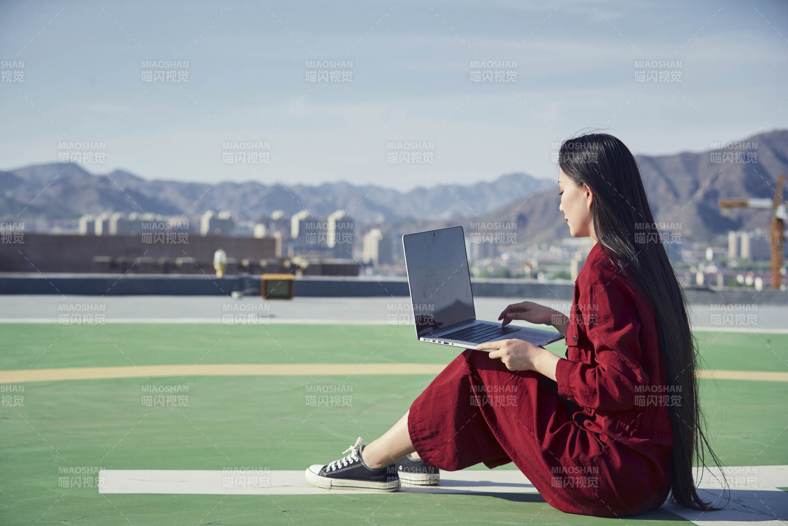 亞洲商務年輕女性在樓頂停機坪使用電腦辦公
