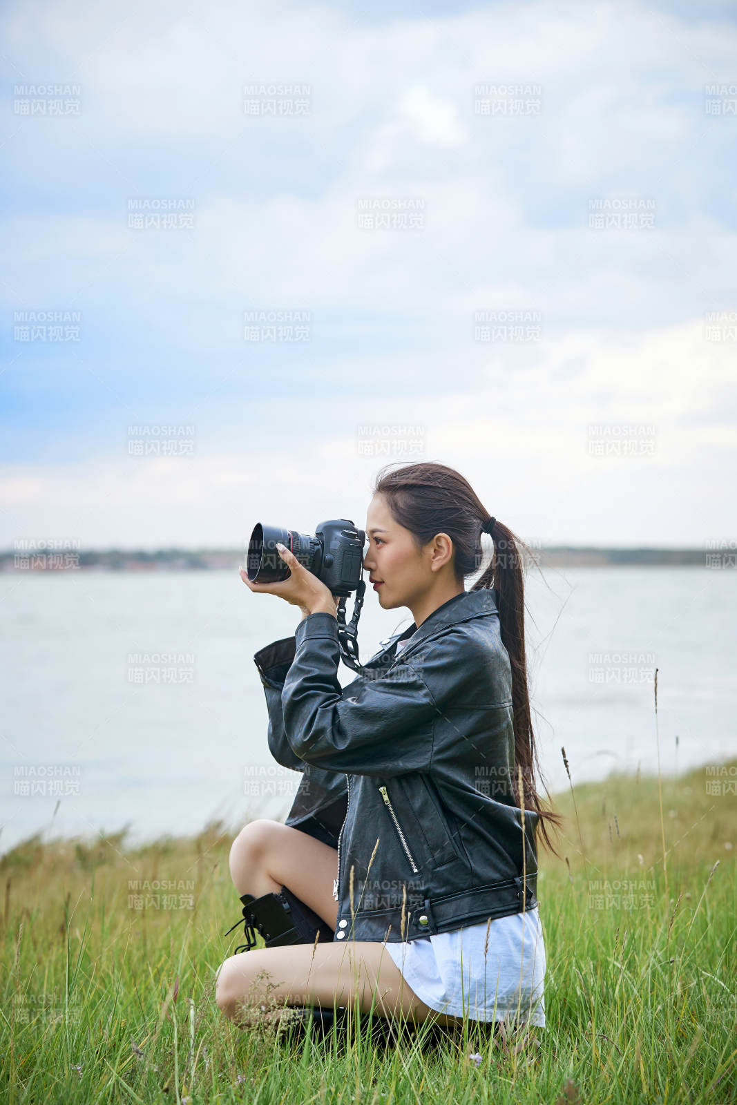 戶外湖畔進(jìn)行拍攝的亞洲青年女性攝影師