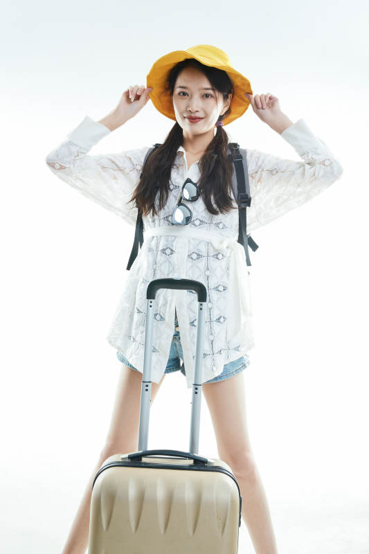 白色背景下准备出发旅行的美丽东方女大学生