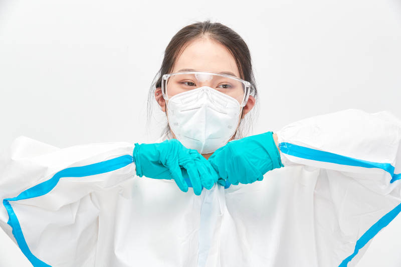 穿白色防护服佩戴护目镜口罩的女性医疗人员