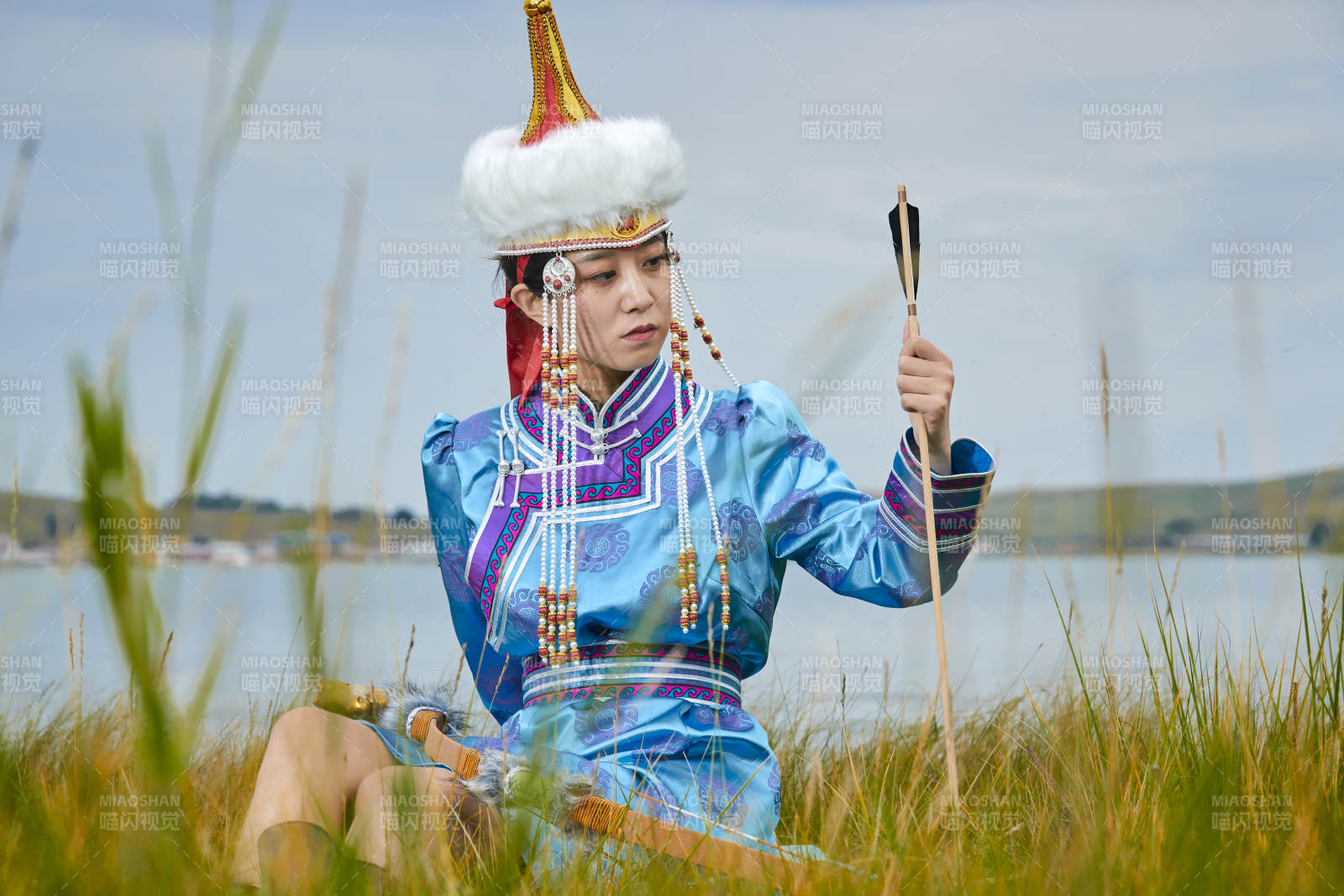 草原湖畔身穿蒙古族飾手持弓箭的蒙族少女