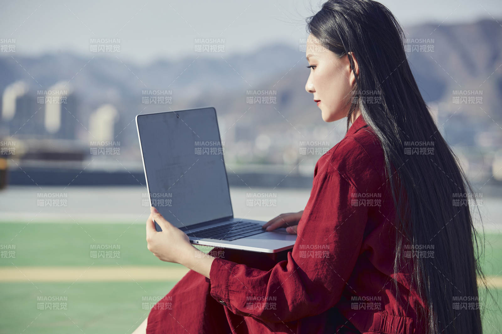 亞洲商務年輕女性在樓頂停機坪使用電腦辦公