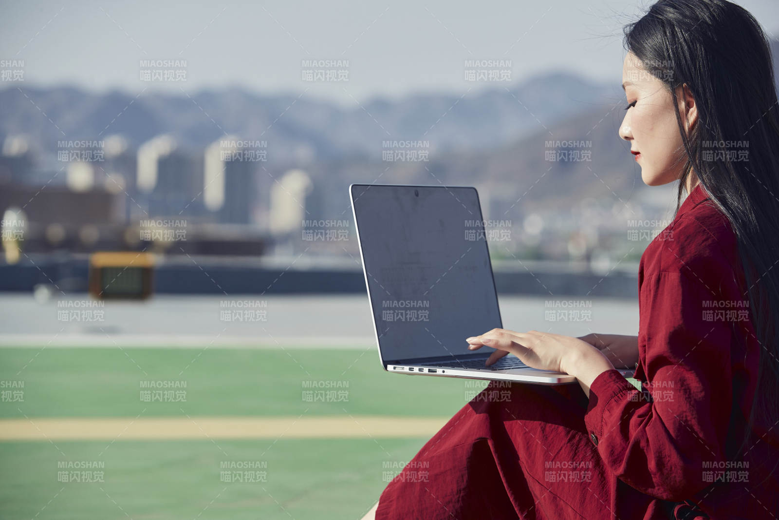亞洲商務年輕女性在樓頂停機坪使用電腦辦公