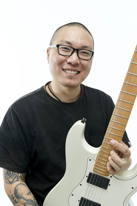 手持电吉他展示演奏的亚洲男性摇滚乐手人像