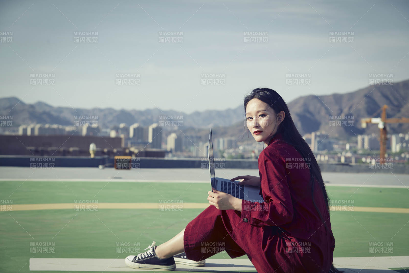 亞洲商務年輕女性在樓頂停機坪使用電腦辦公