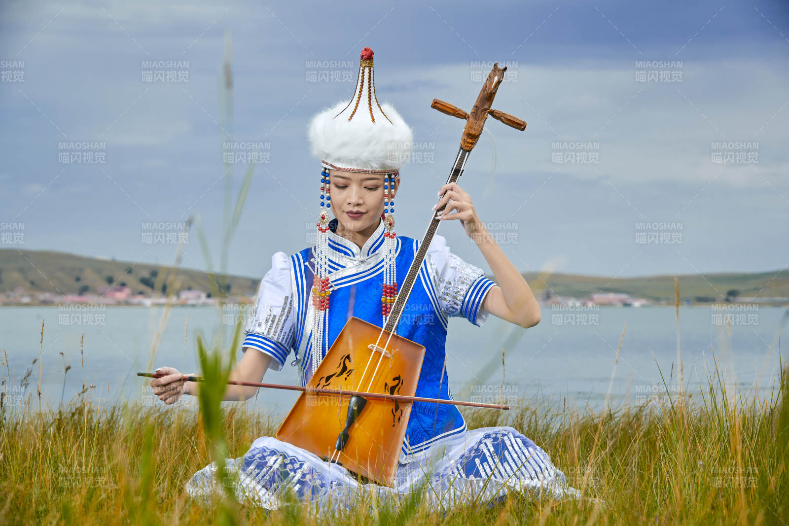 草原上穿蒙古族服飾拉馬頭琴的蒙族女樂手