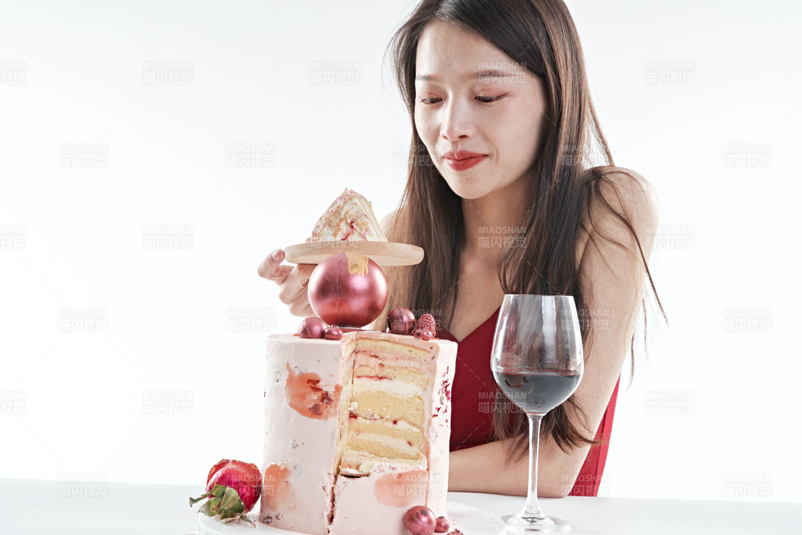 喝紅酒品嘗蛋糕的年輕女性