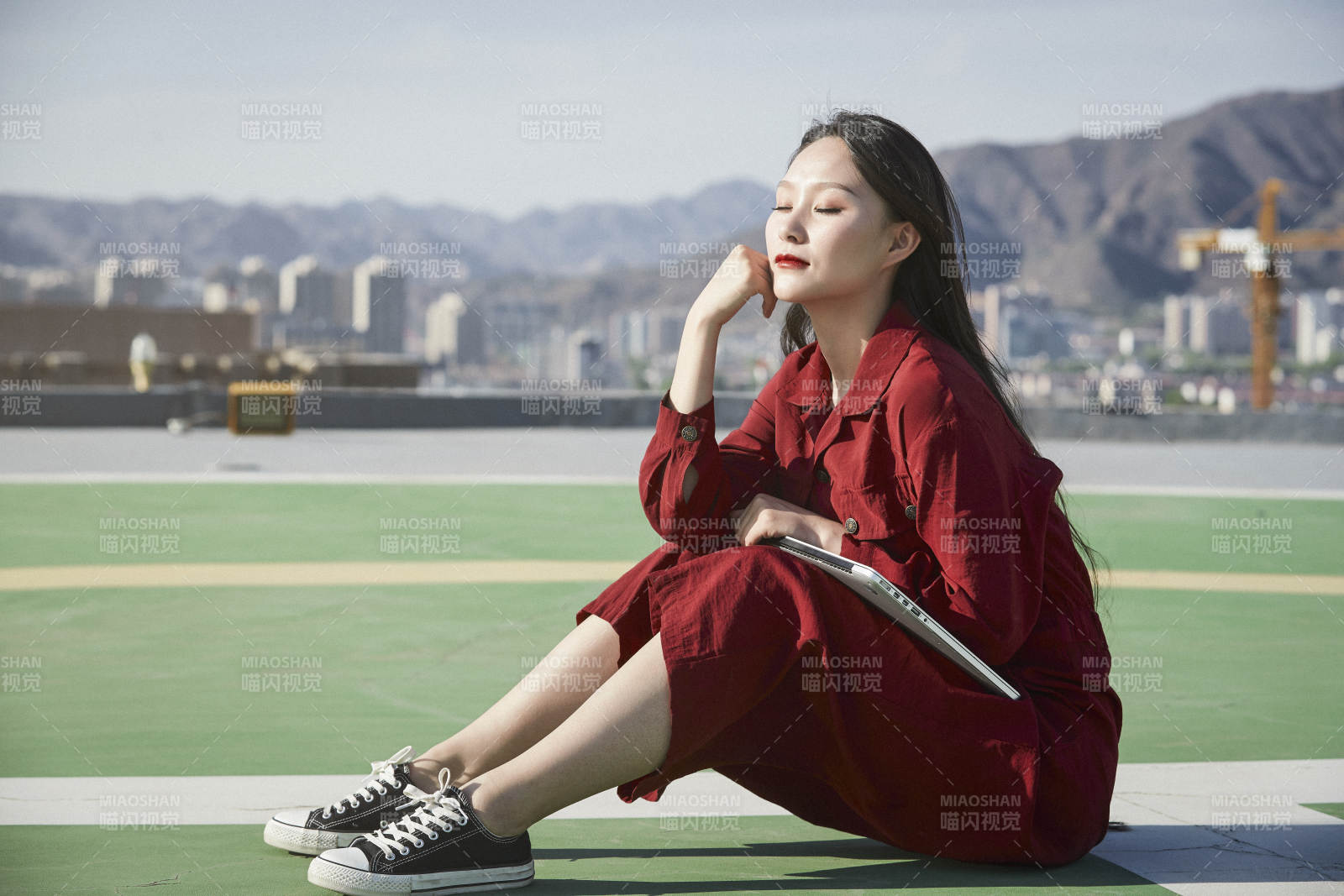 亞洲商務年輕女性在樓頂停機坪使用電腦辦公