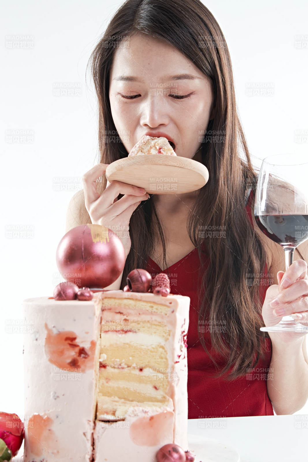 喝紅酒品嘗蛋糕的年輕女性