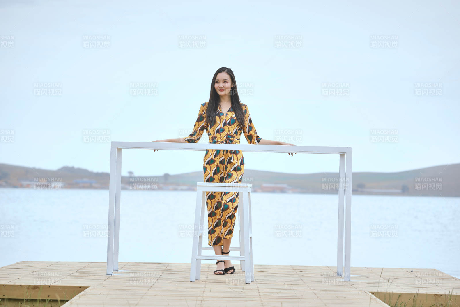 悠閑的坐在美麗湖岸碼頭的亞洲年輕女性人像