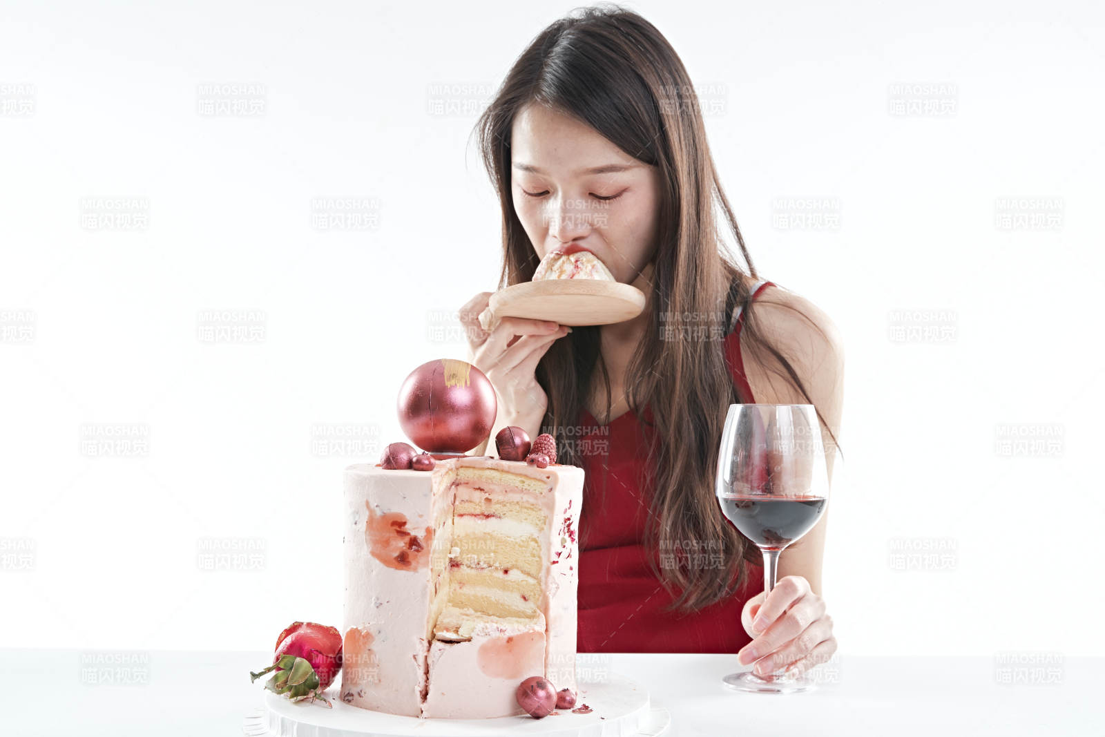 喝紅酒品嘗蛋糕的年輕女性