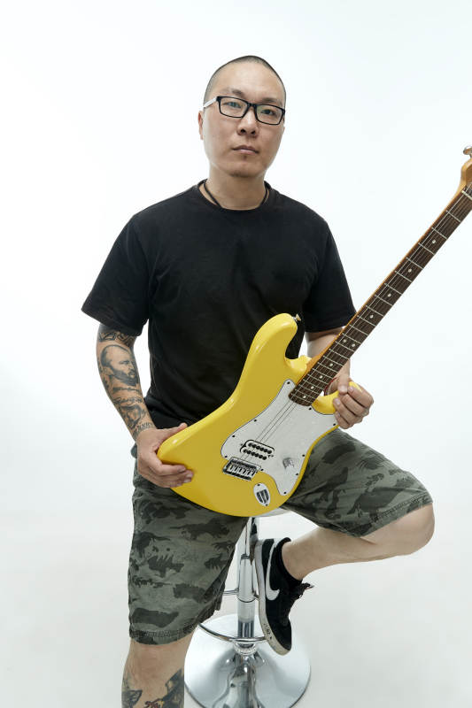 手持电吉他展示演奏的亚洲男性摇滚乐手人像