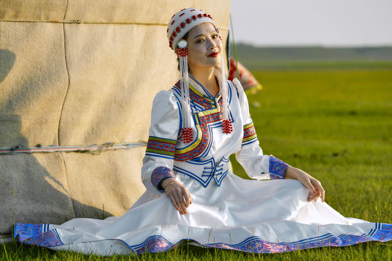 草原上穿着蒙古族传统服饰的亚洲年轻美少女