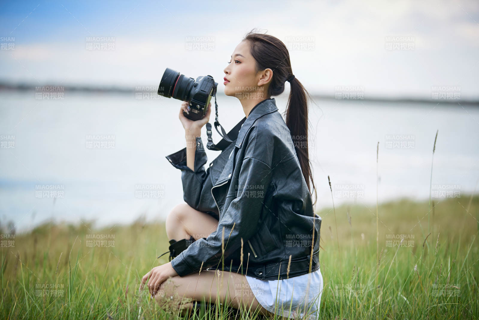 戶外湖畔進行拍攝的亞洲青年女性攝影師