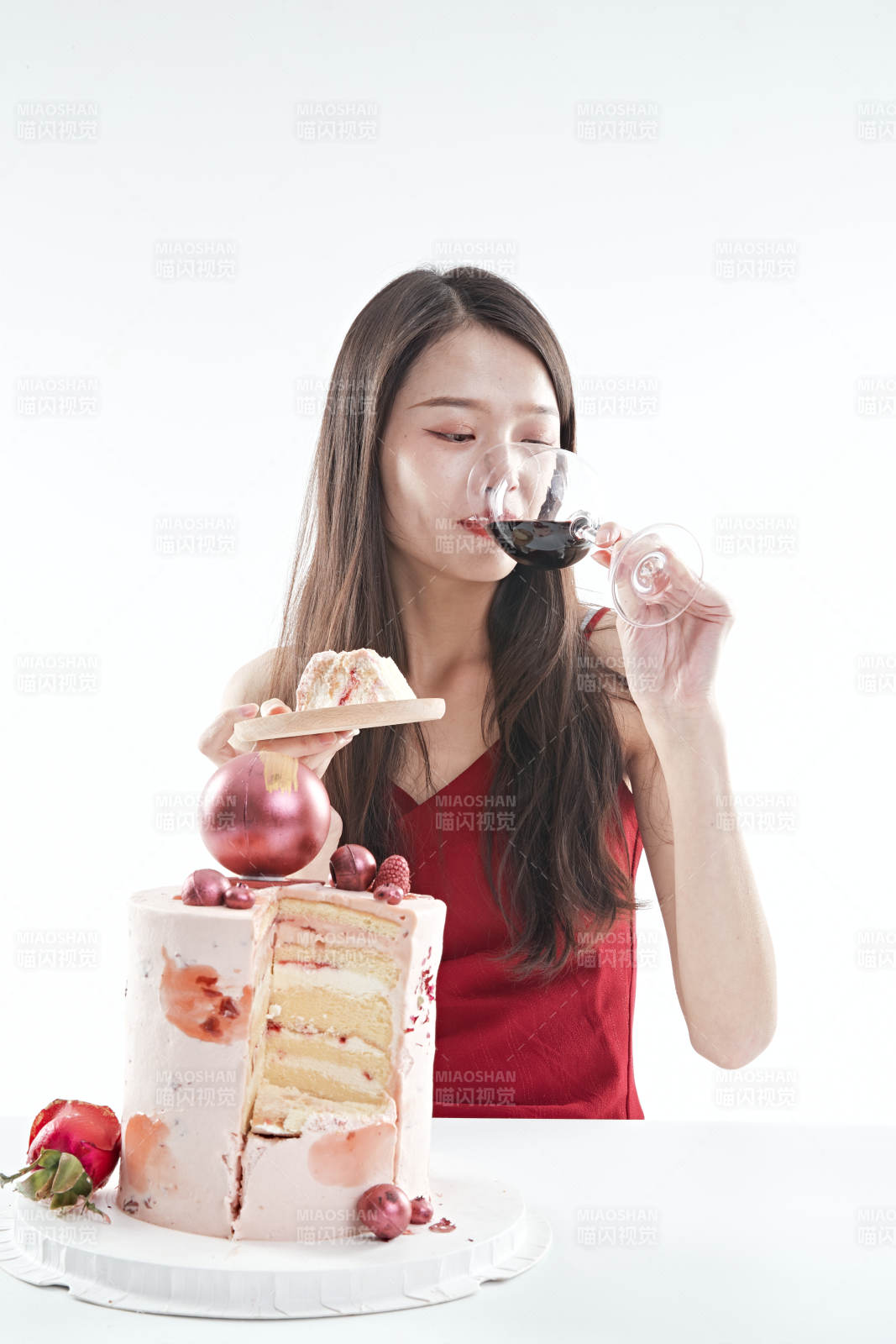 喝紅酒品嘗蛋糕的年輕女性