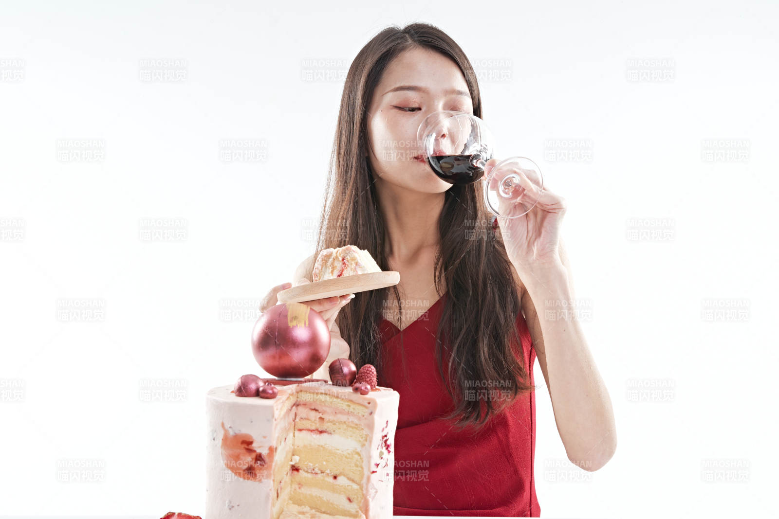 喝紅酒品嘗蛋糕的年輕女性