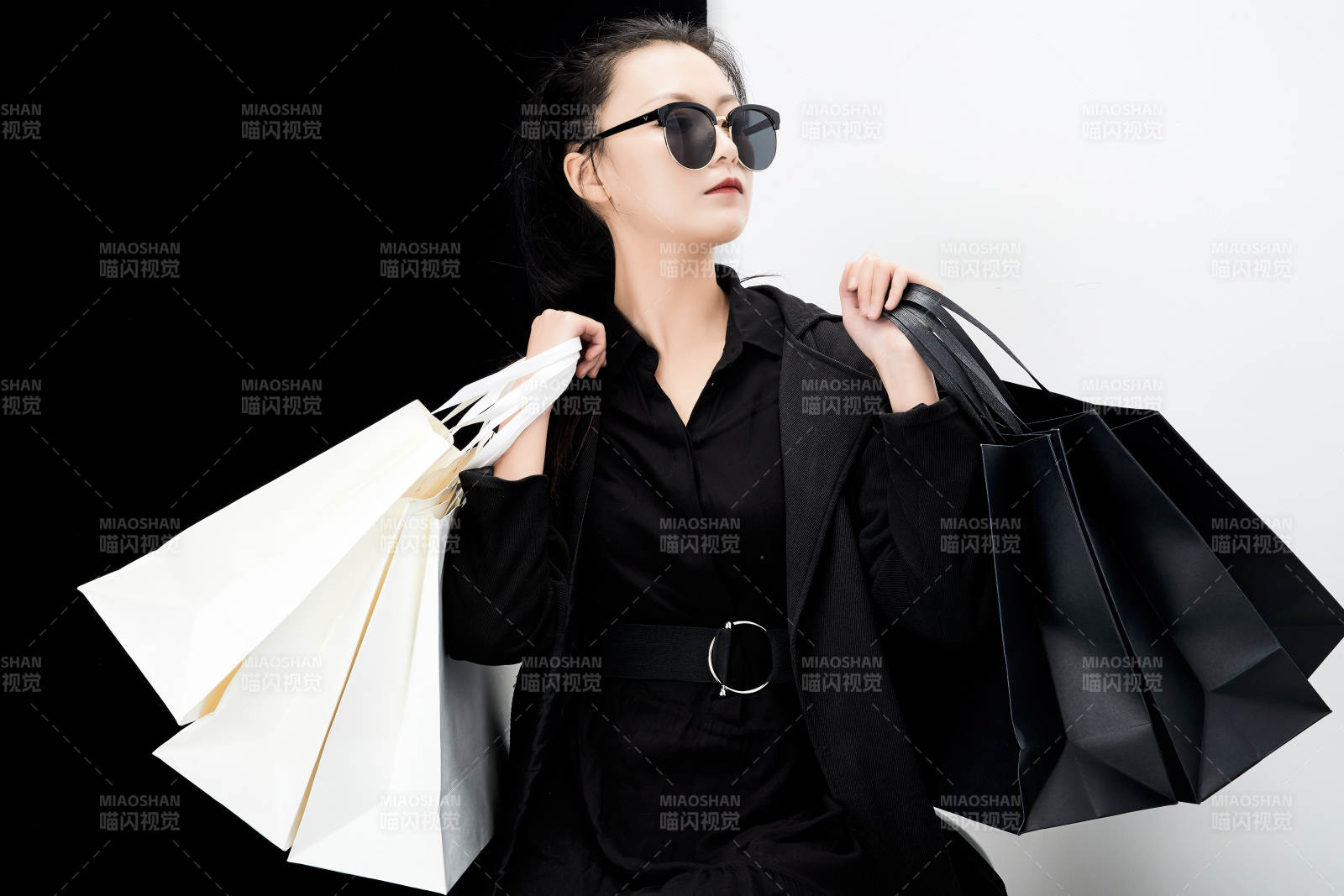 黑白色背景下的手提購物袋的時尚亞洲少女