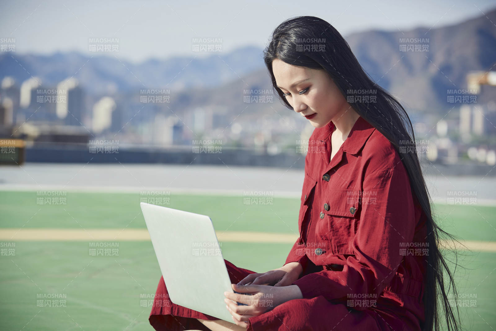 亞洲商務(wù)年輕女性在樓頂停機坪使用電腦辦公