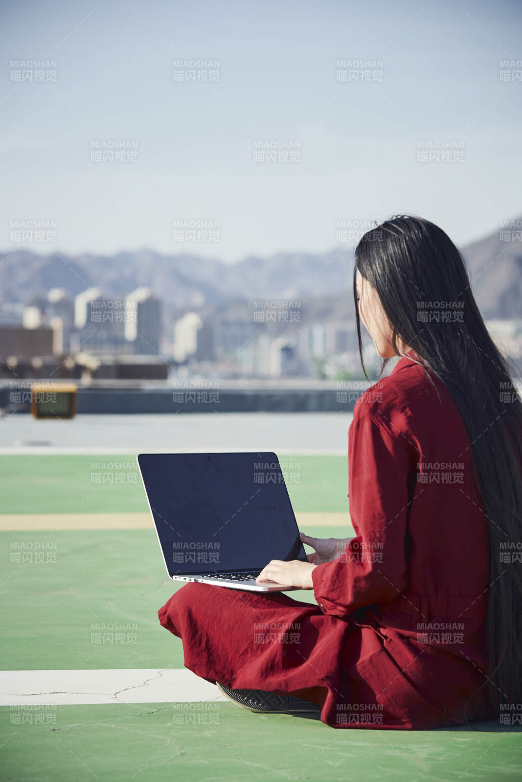 亞洲商務年輕女性在樓頂停機坪使用電腦辦公