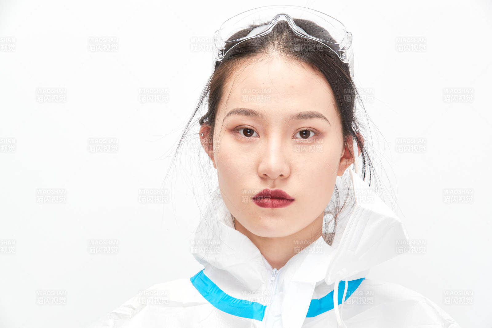 穿白色防護服佩戴護目鏡口罩的女性醫(yī)療人員