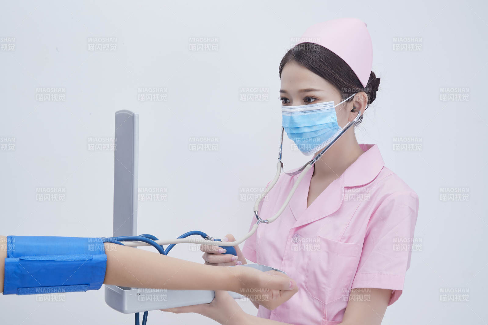 手拿血壓測量儀為患者診治量血壓的女性護士