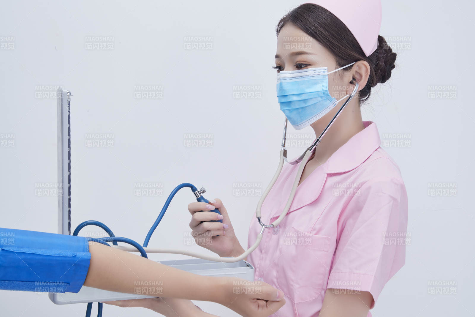 手拿血壓測量儀為患者診治量血壓的女性護士