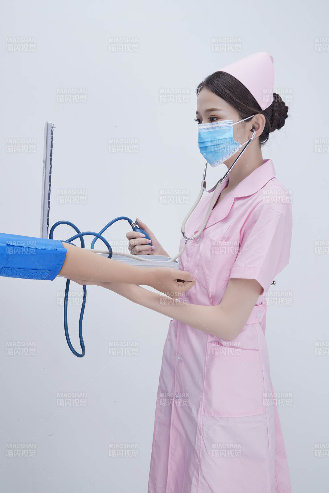 手拿血壓測量儀為患者診治量血壓的女性護士