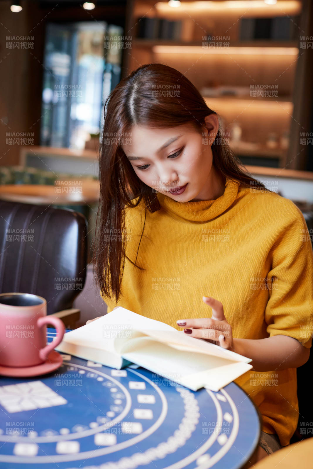 在圖書咖啡館閱讀書籍的少女
