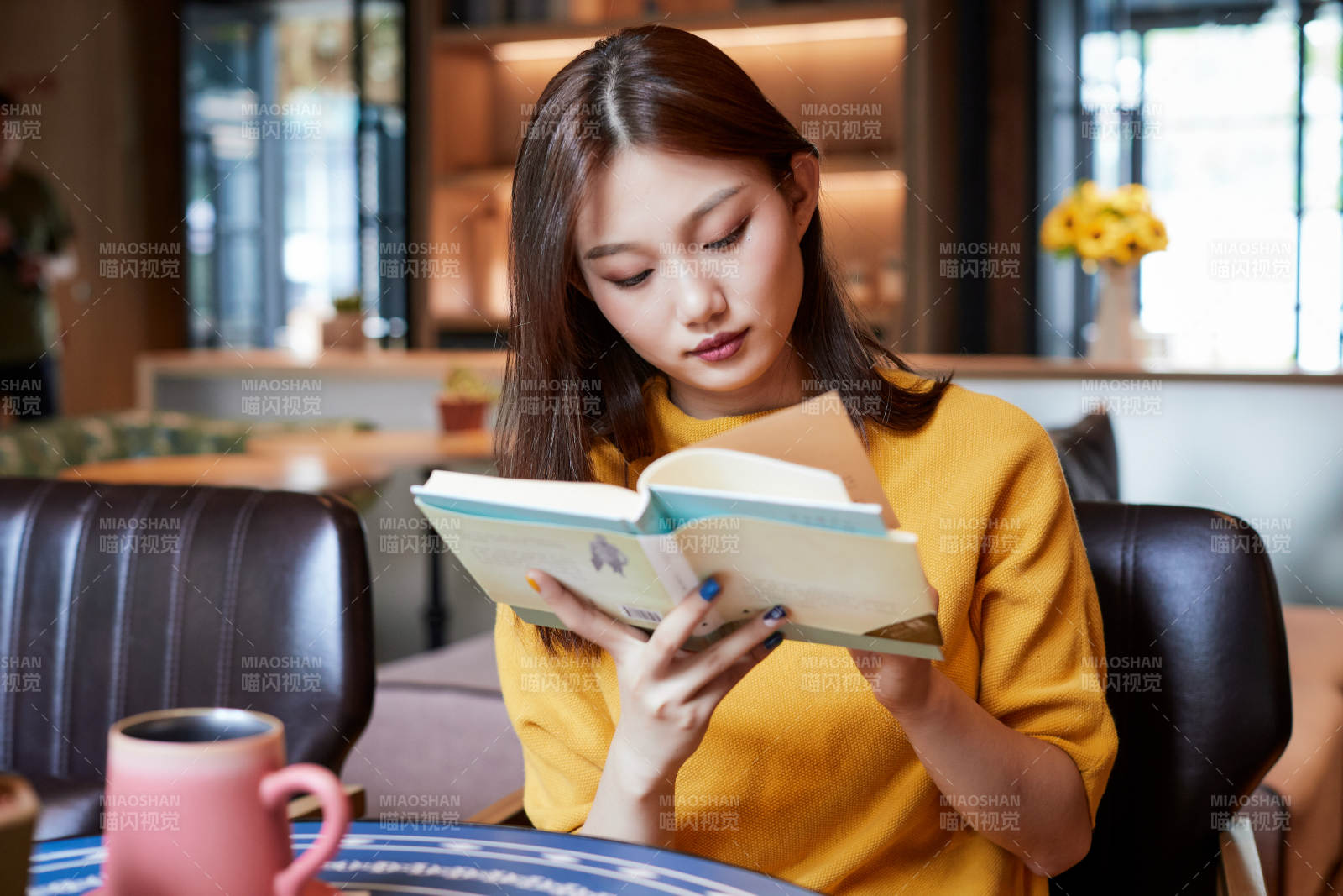 在圖書咖啡館閱讀書籍的少女